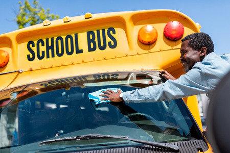 Bus driver cleaning bus windows 