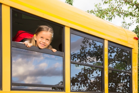girl child looking out school bus window